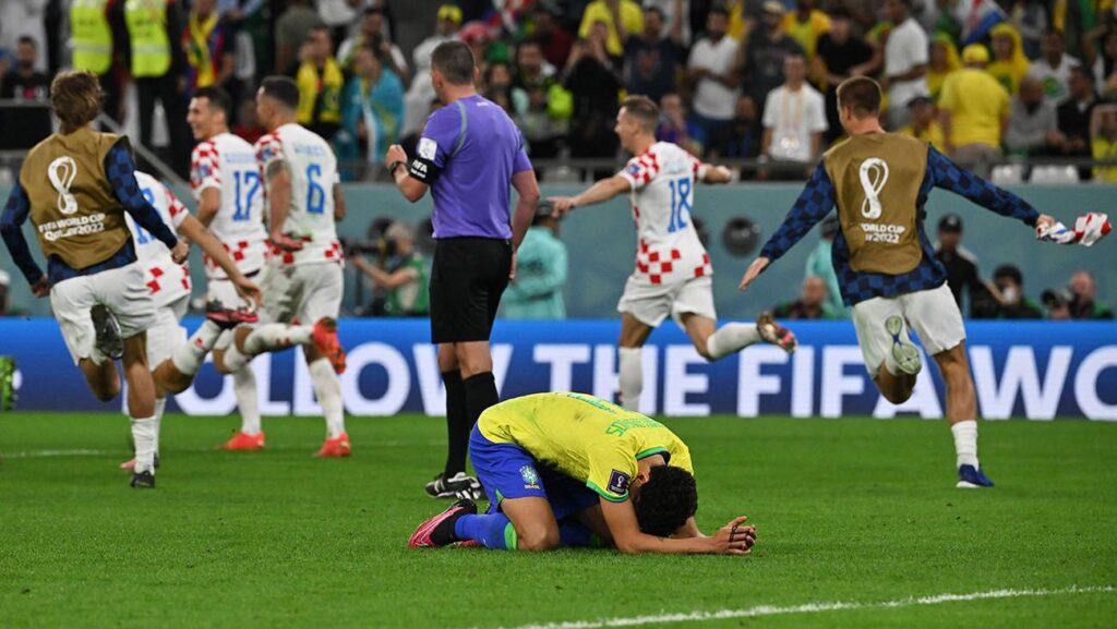 Marquinhos laments after missing the fourth and decisive penalty, while the Croats celebrate their classification
