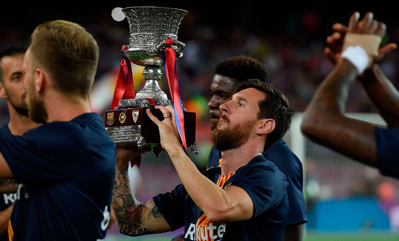 Leo Messi poses with the Supercopa of Europe
