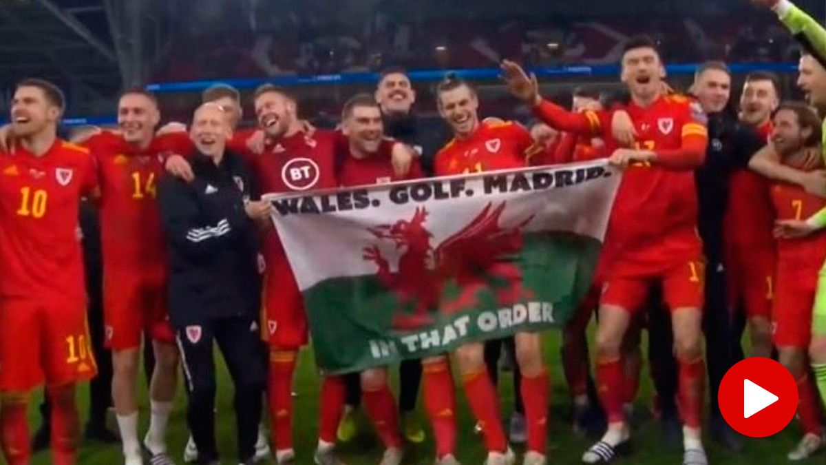 Gareth Bale and the players of Wales celebrate with a banner that mocks Real Madrid