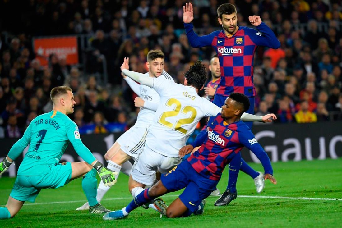 La defensa del Barça despeja una llegada del Madrid