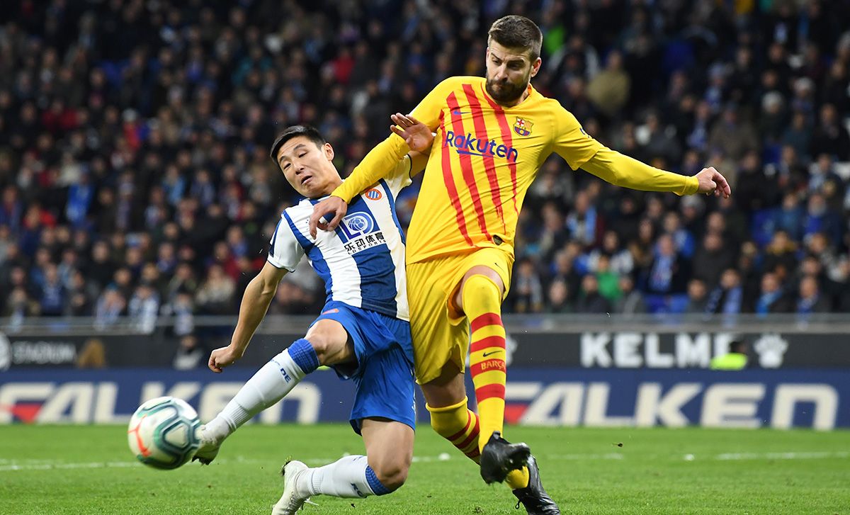 Gerard Piqué, fighting for a ball with Wu Lei