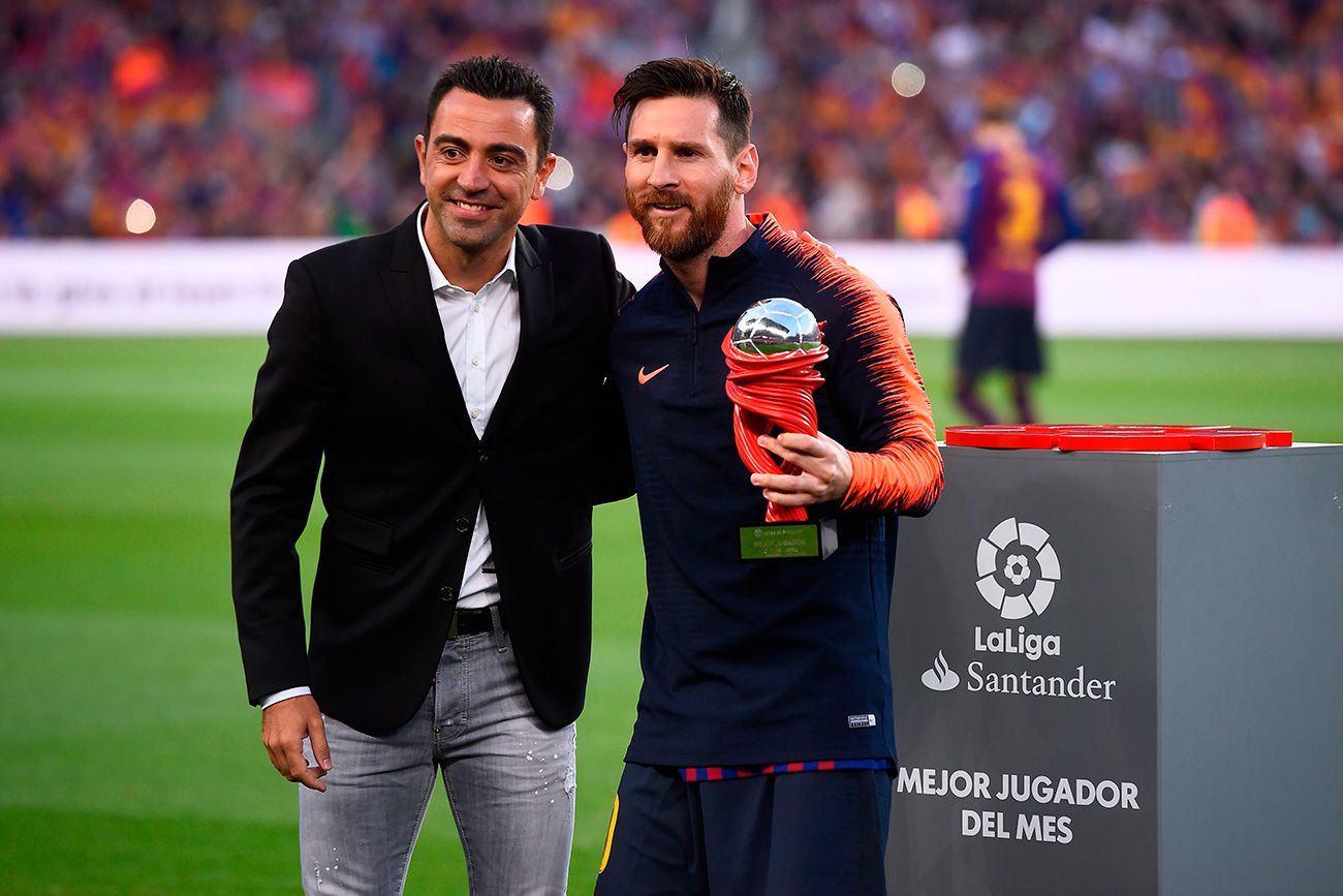 Xavi and Leo Messi pose with a trophy