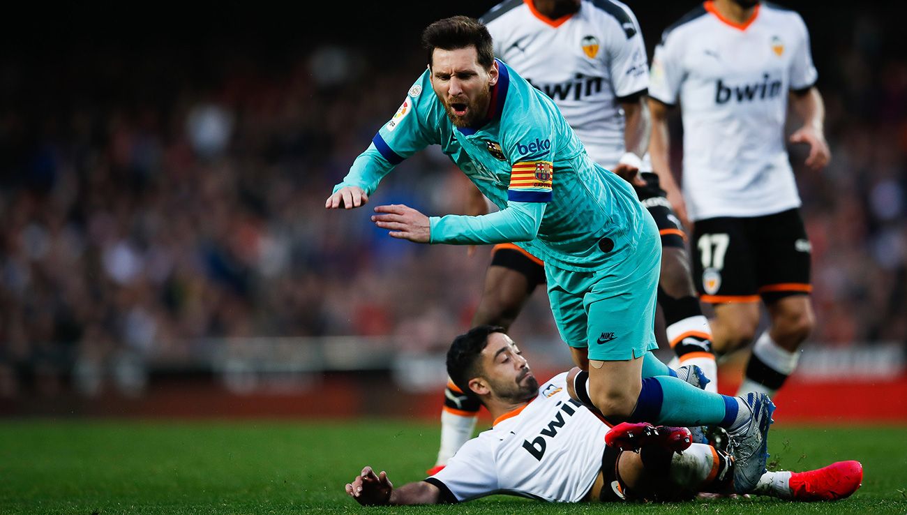Leo Messi falls  to the floor after an entrance of Jaume Coast