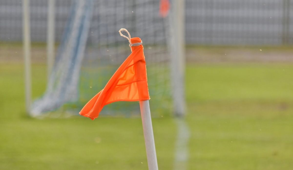 Imagen de un banderín de córner en un campo de fútbol amateur