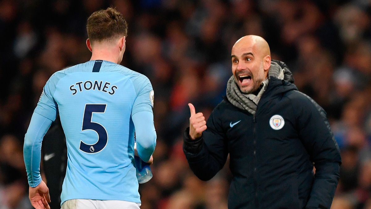 Pep Guardiola y John Stones en un partido del Manchester City