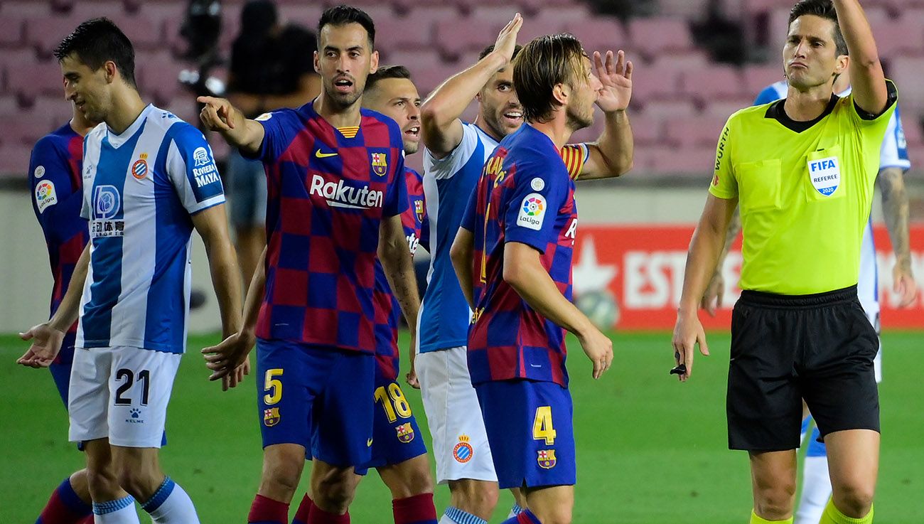 Busquets and Rakitic complain to the referee after an action
