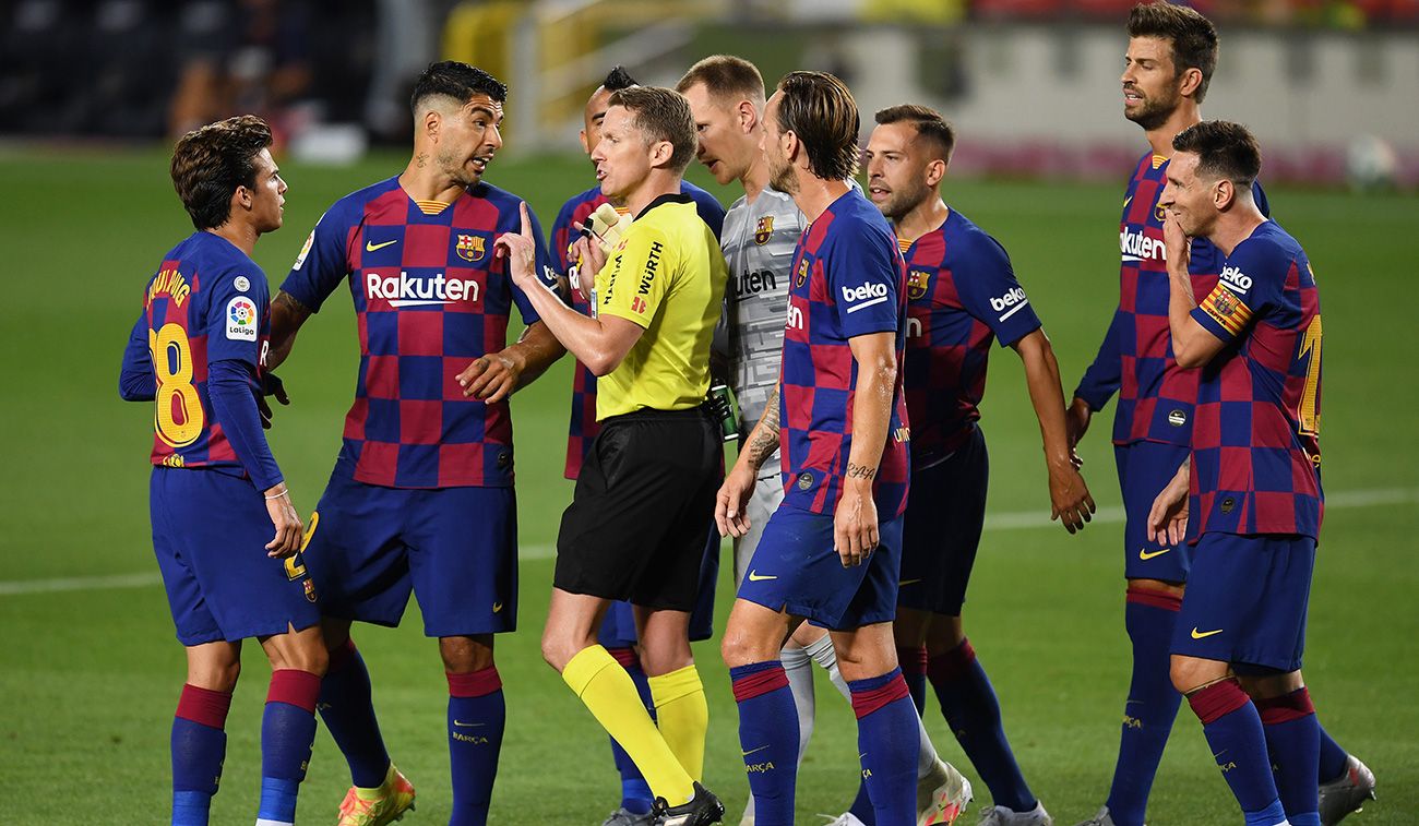 Los jugadores del Barça rodean al árbitro Hernández Hernández