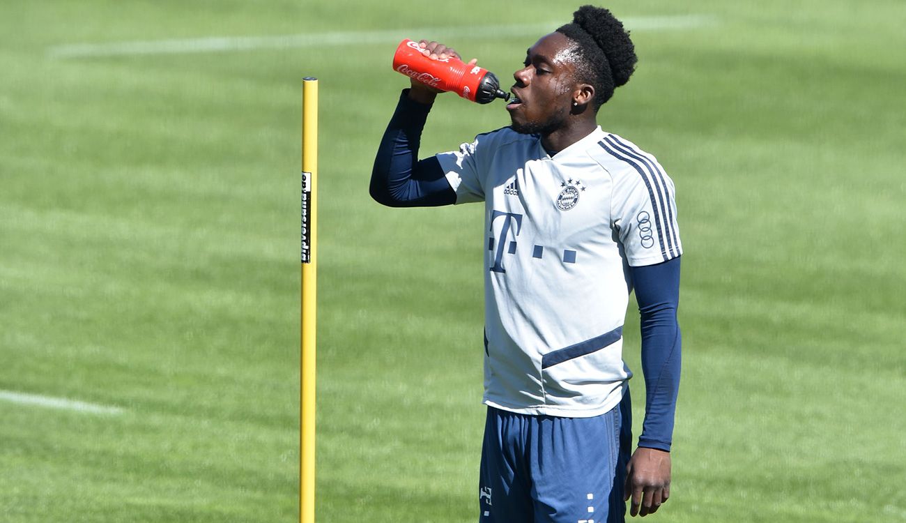 Alphonso Davies bebe agua en un entrenamiento del Bayern