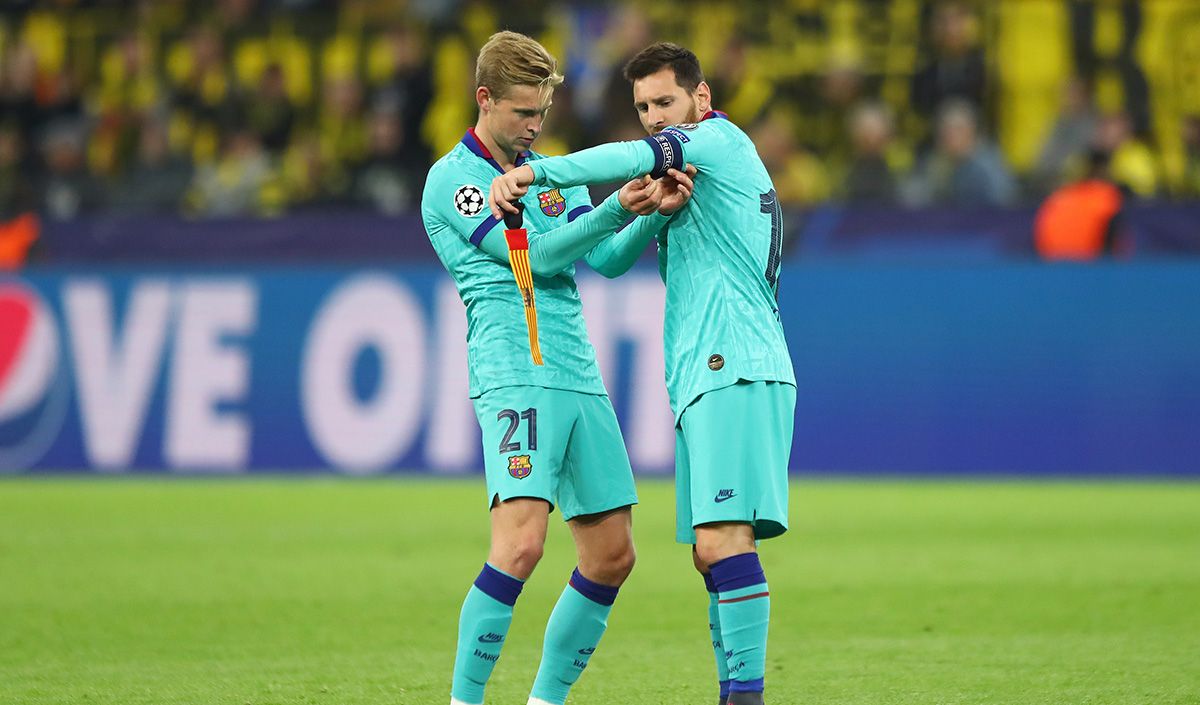 Frenkie de Jong, intentando poner el brazalete de capitán a Leo Messi