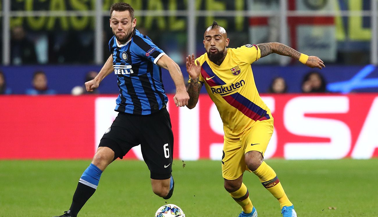 De Vrij y Vidal pelean por un balón en el Inter-Barça