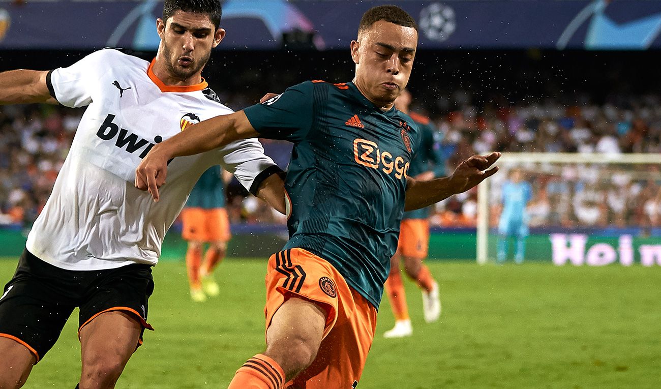 Sergiño Dest lucha contra Guedes en un Valencia-Ajax