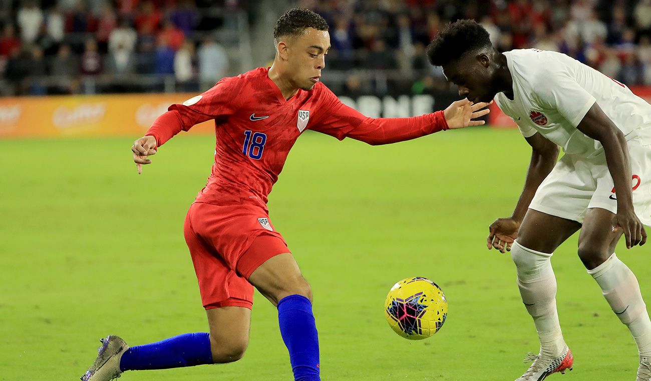 Sergiño Dest intenta tirarle un caño a Alphonso Davies en un USA-Canadá