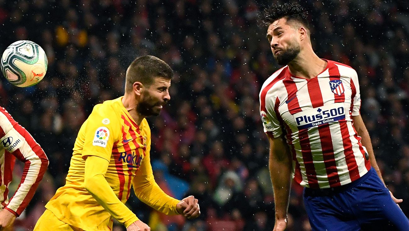 Piqué y Felipe saltan a un balón en un Atlético-Barça