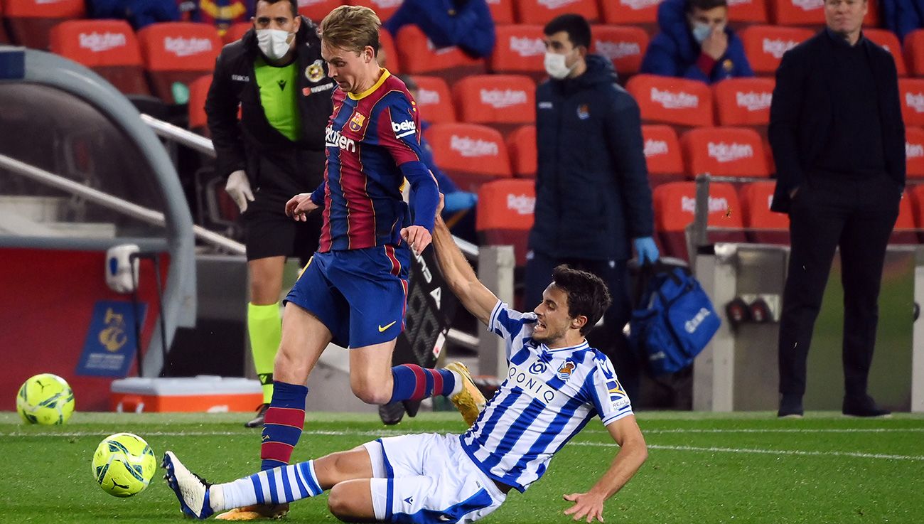 Frenkie Of Jong drives in front of a player of the Real