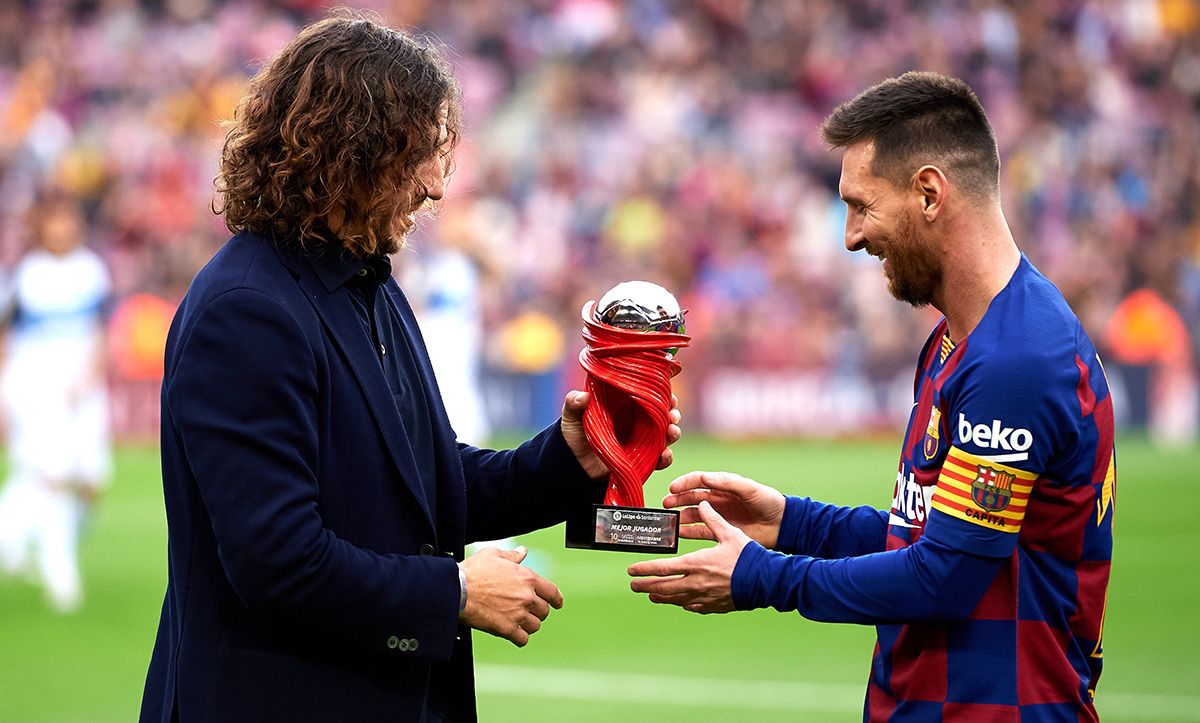 Carles Puyol, entregando a Leo Messi el premio a mejor jugador del mes