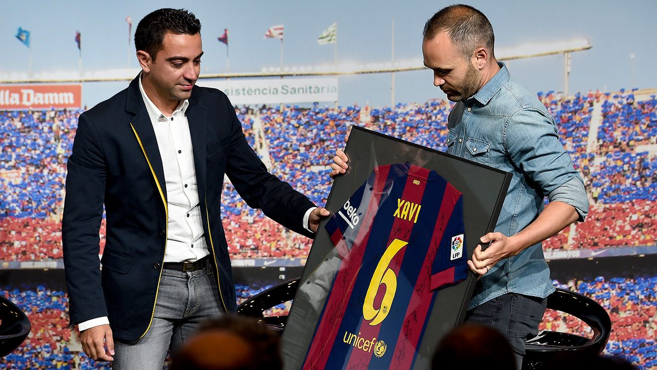 Andrés Iniesta le da una camiseta a Xavi Hernández