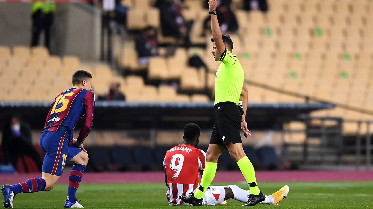 Gil Manzano takes out a card to a player of the Barça