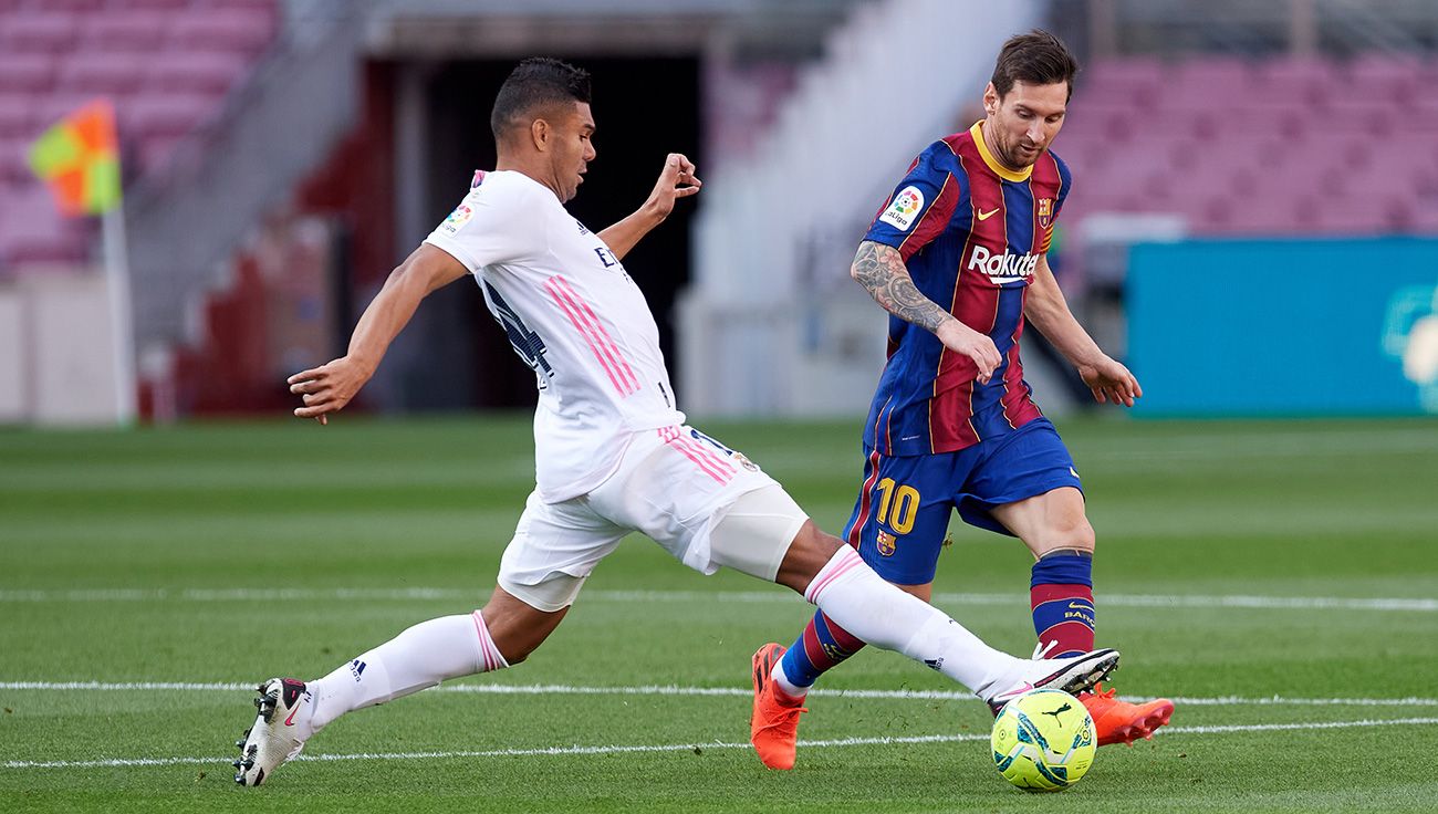 Casemiro intenta quitarle la pelota a Messi