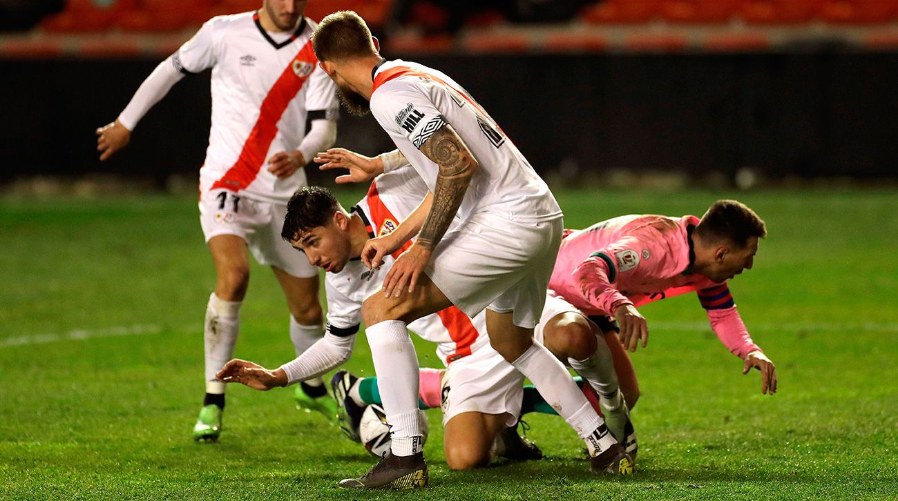 Leo Messi falls in front of an entrance of a defence of the Ray