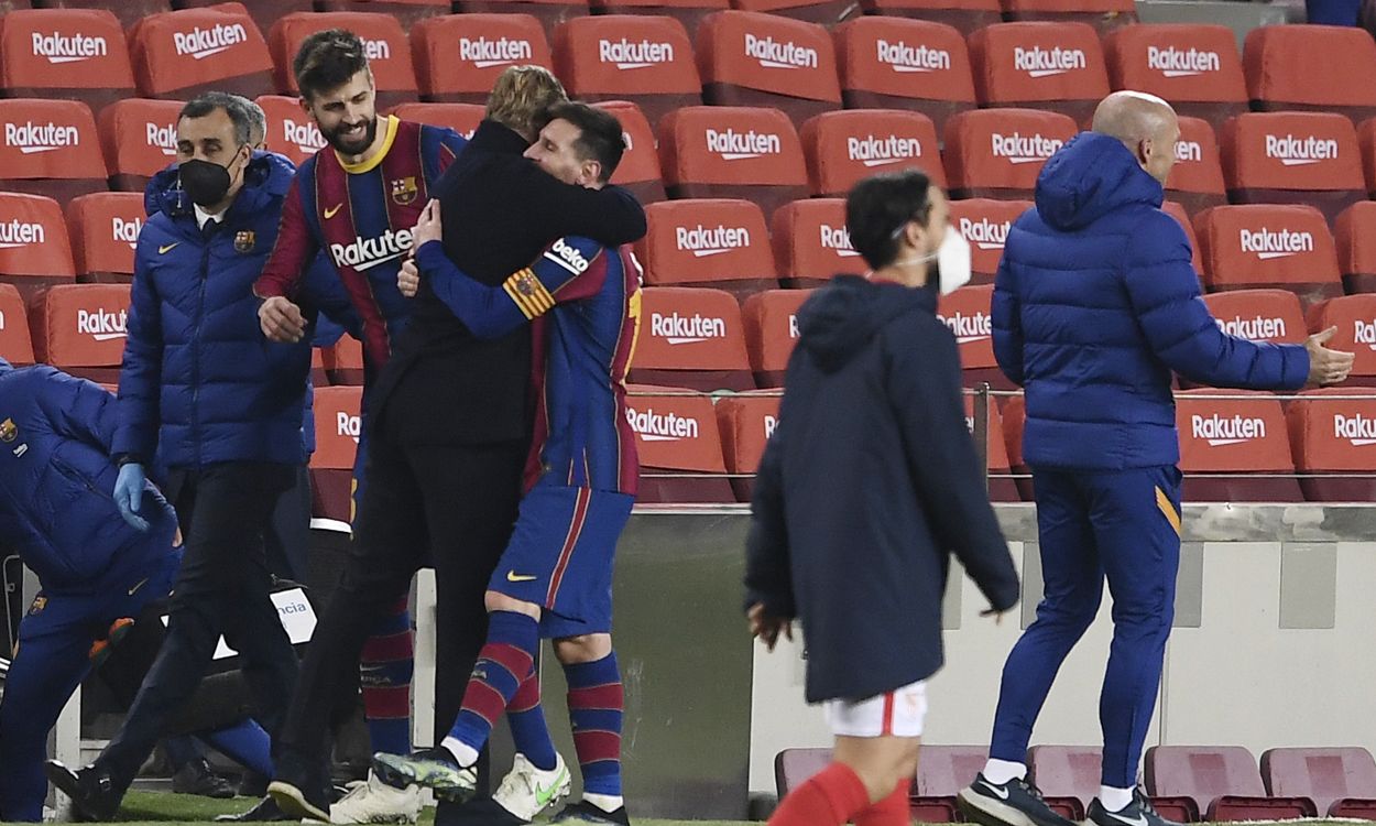 Messi y Koeman se abrazan tras un partido del Barça