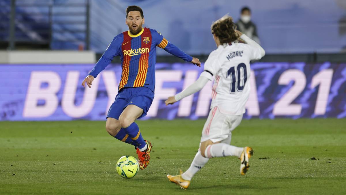 Lionel Messi contests the balloon with Luka Modric