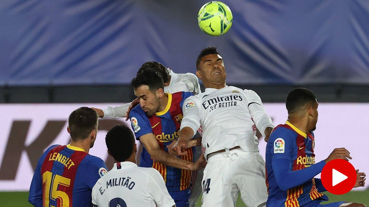 Jugadores de FC Barcelona y Real Madrid, disputando un balón