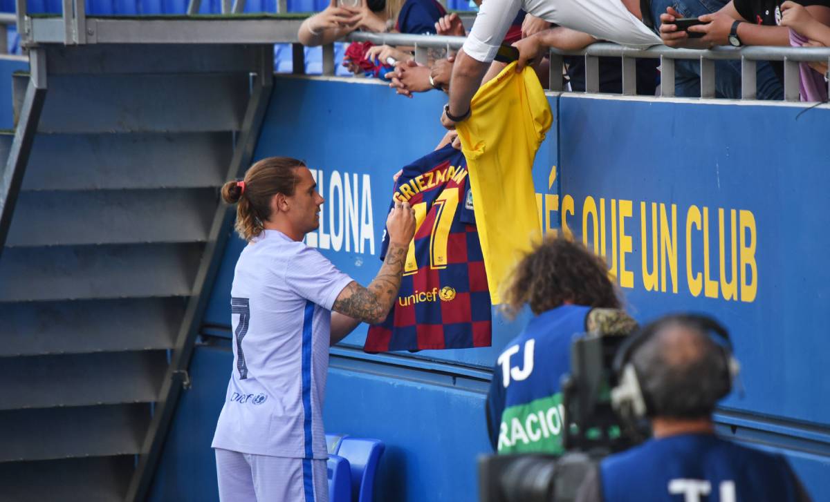 Antoine Griezmann signs the T-shirt of a fan