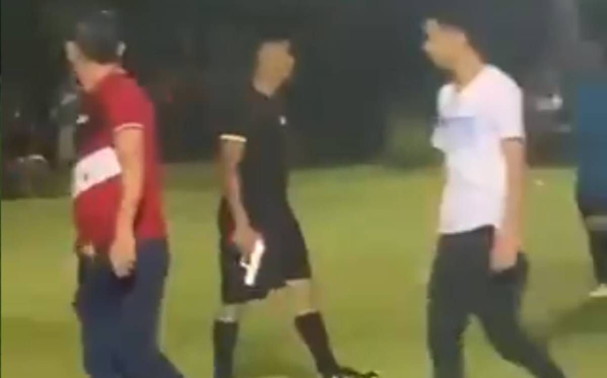 A referee takes out a gun during a party in Honduras