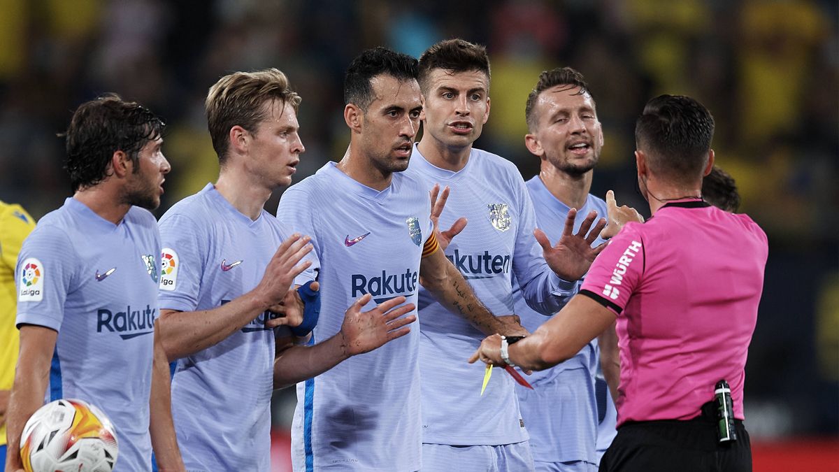 Barça players claiming Carlos del Cerro Grande in a match against Cádiz