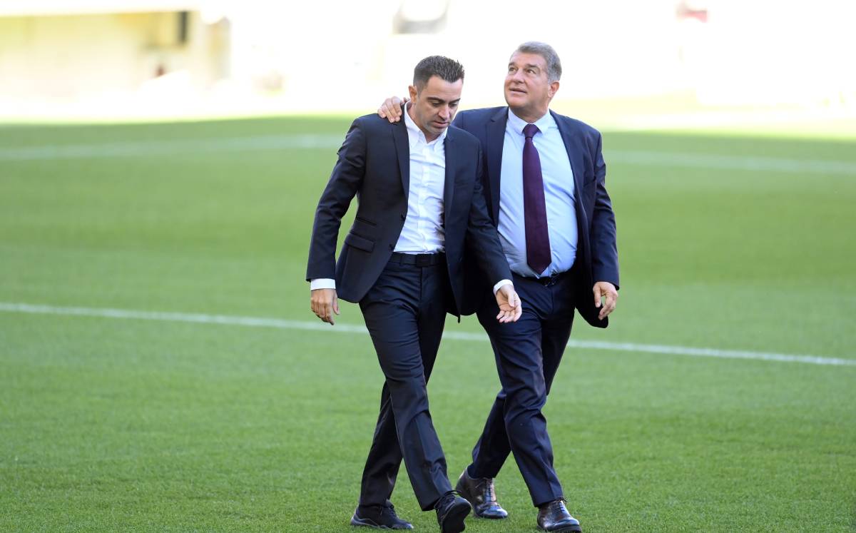 Xavi Hernández beside Joan Laporta