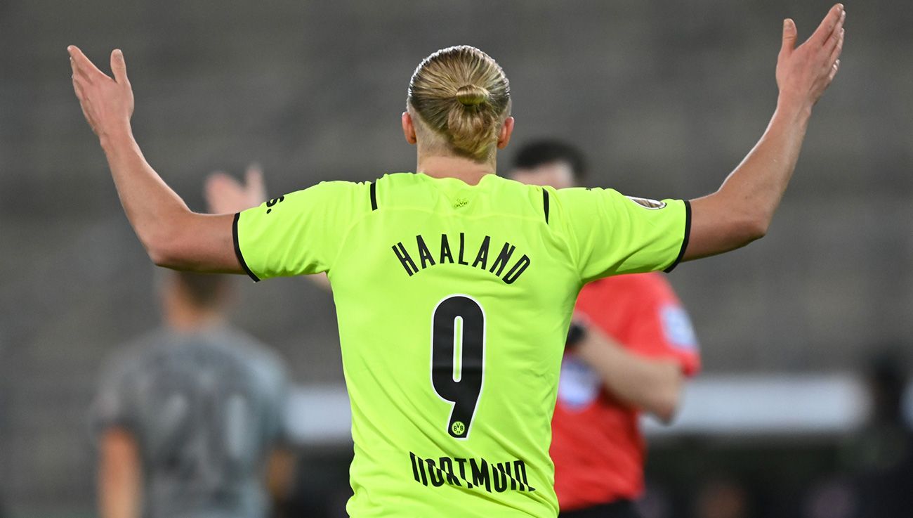 Haaland raising his arms in front of the referee