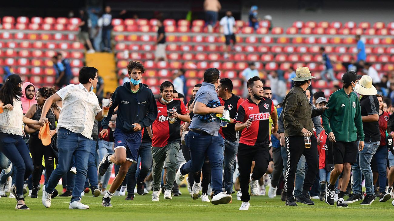 Fanáticos del Atlas invaden el campo del Estadio La Corregidora, huyendo de la trifulca en las tribunas
