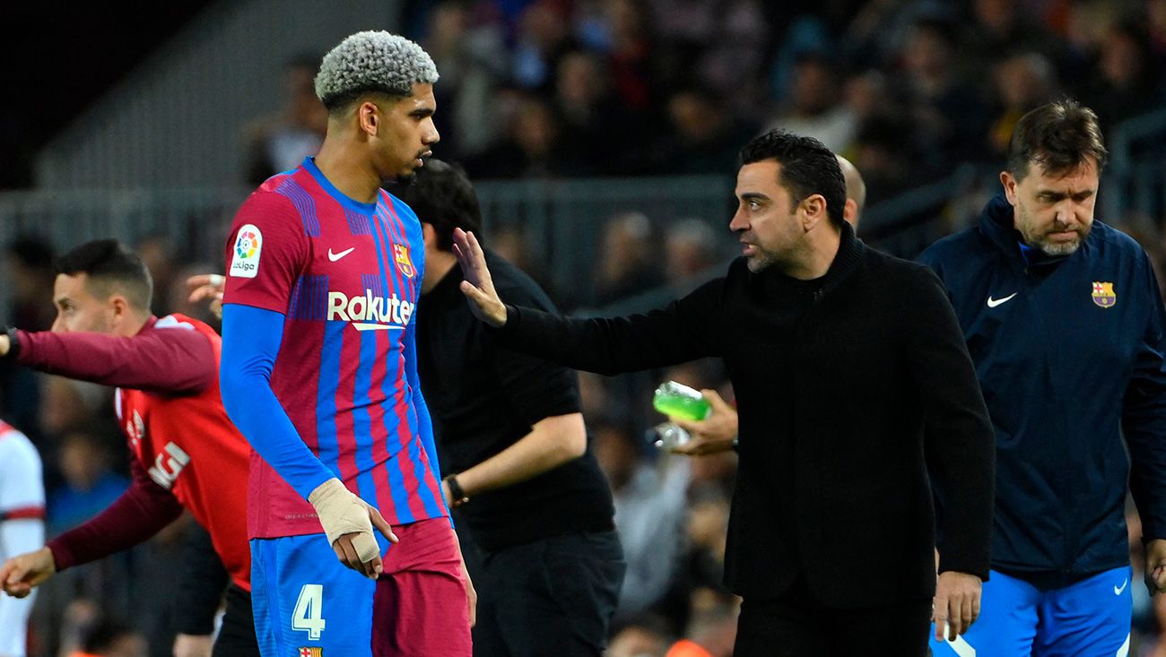 Ronald Araújo y Xavi charlando en la banda