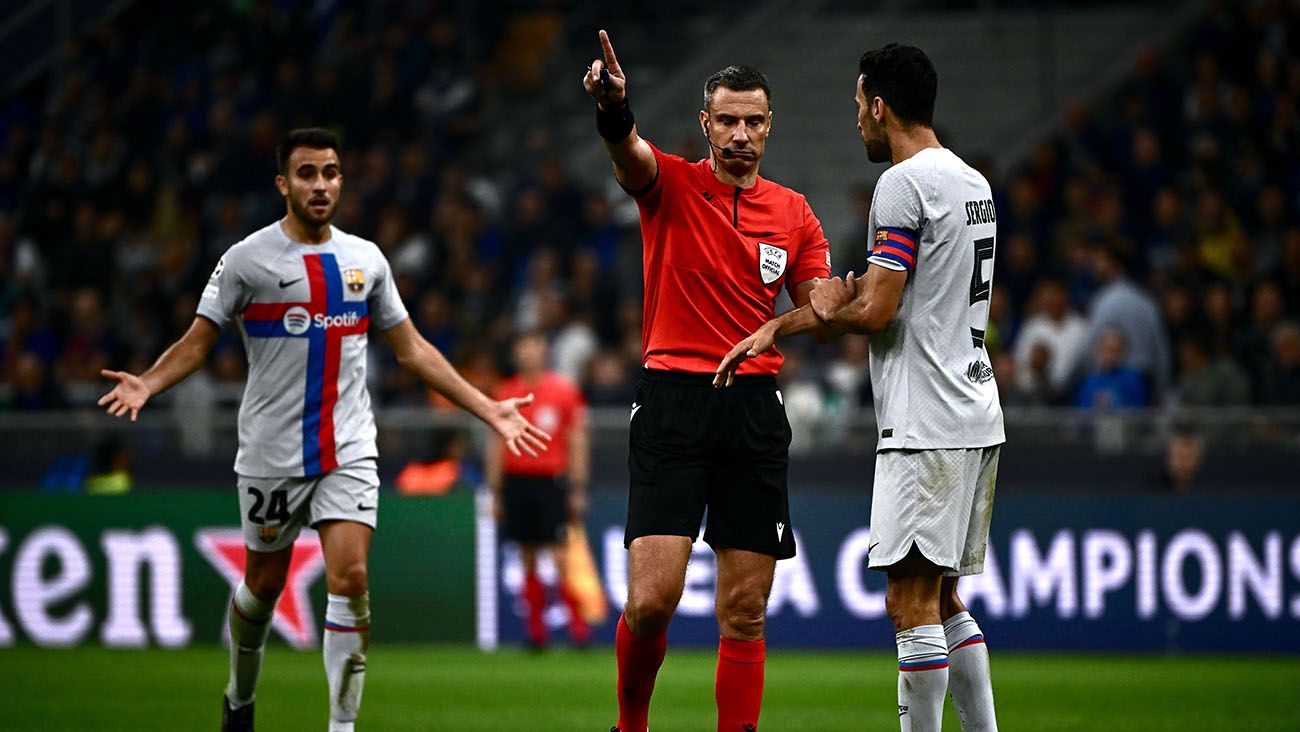 Sergio Busquets and Eric García protest to referee Slavko Vincic