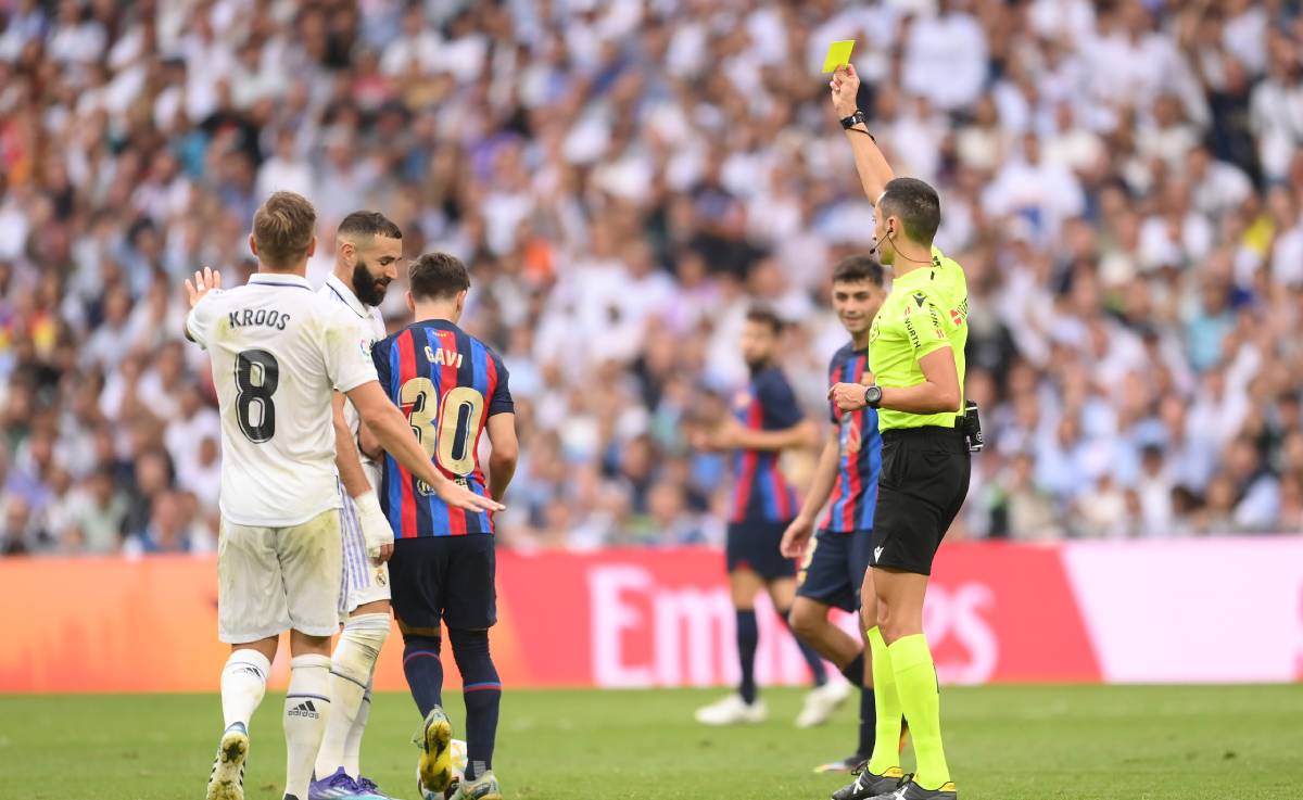 Sánchez Martínez shows a yellow card to Gavi