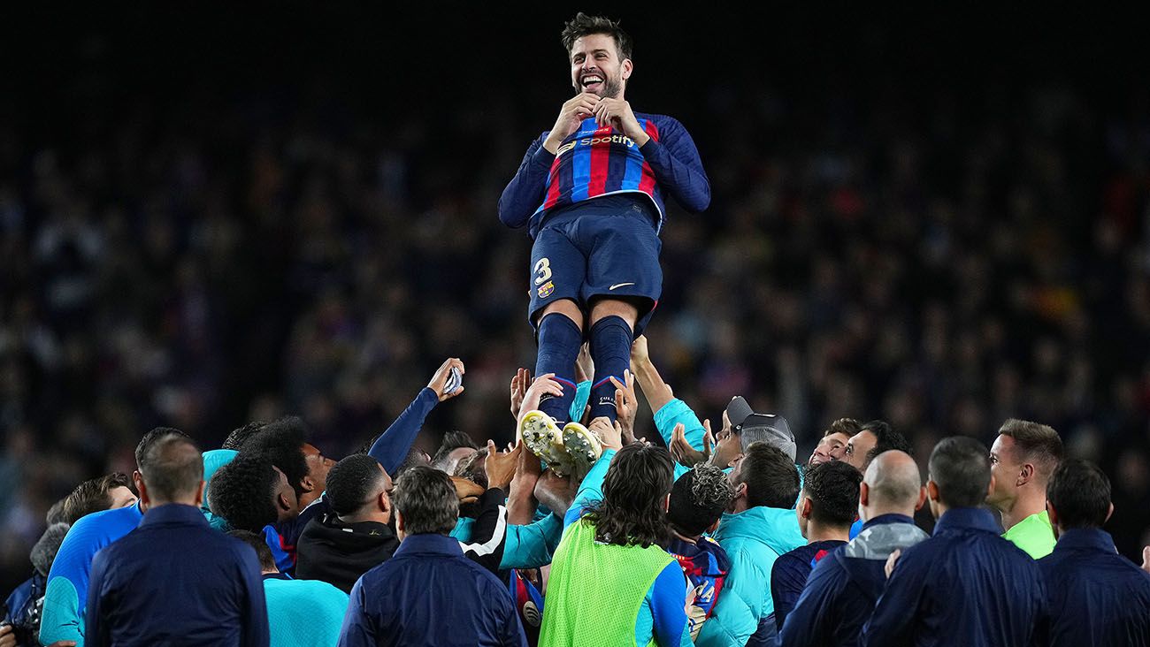 Jugadores del FC Barcelona alzan a Gerard Piqué