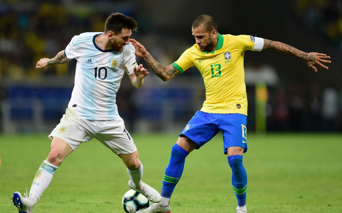 Lionel Messi y Dani Alves disputan el balón