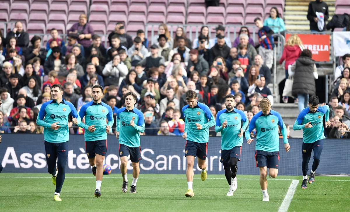 Los jugadores del Barça calientan alrededor del campo
