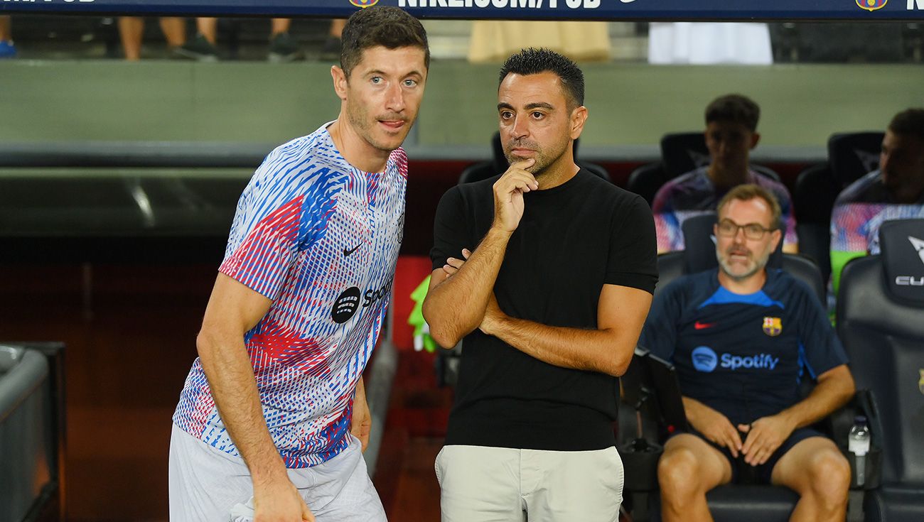 Robert Lewandowski y Xavi durante un partido