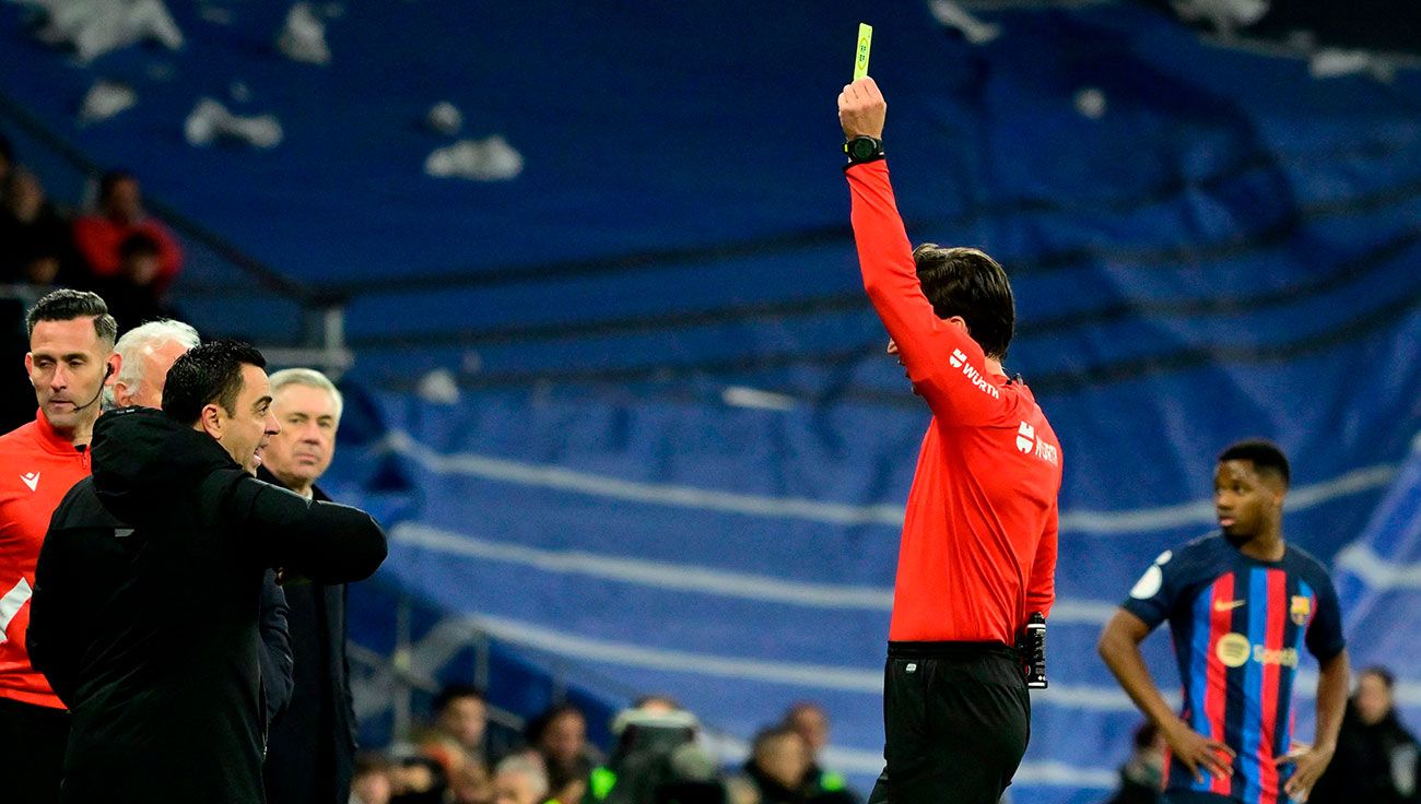Xavi siendo amonestado por el colegiado