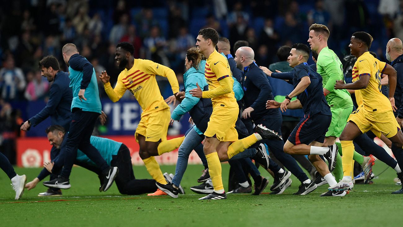 Los jugadores del Barça corren tras la invasión de campo en el derbi