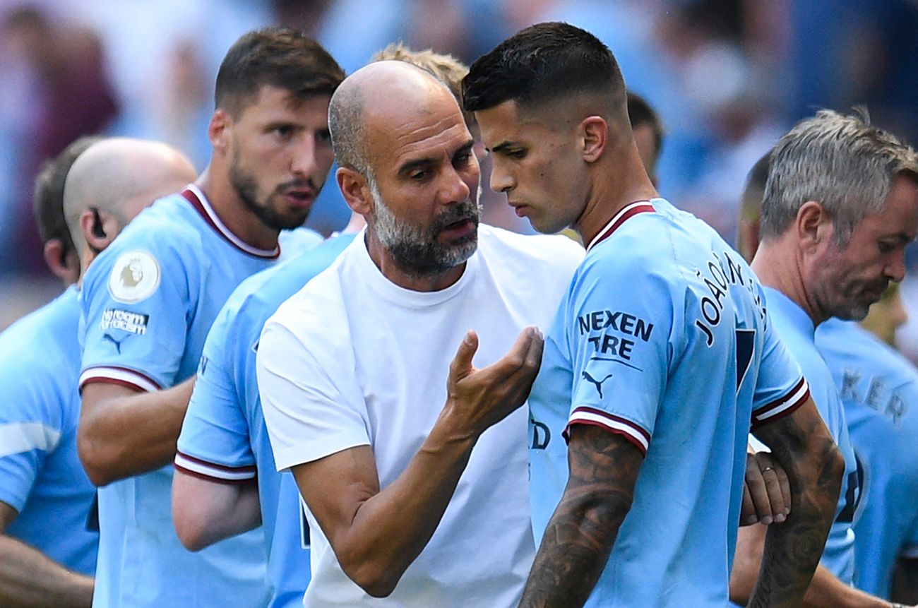 Guardiola y Cancelo conversando en un partido del Manchester City