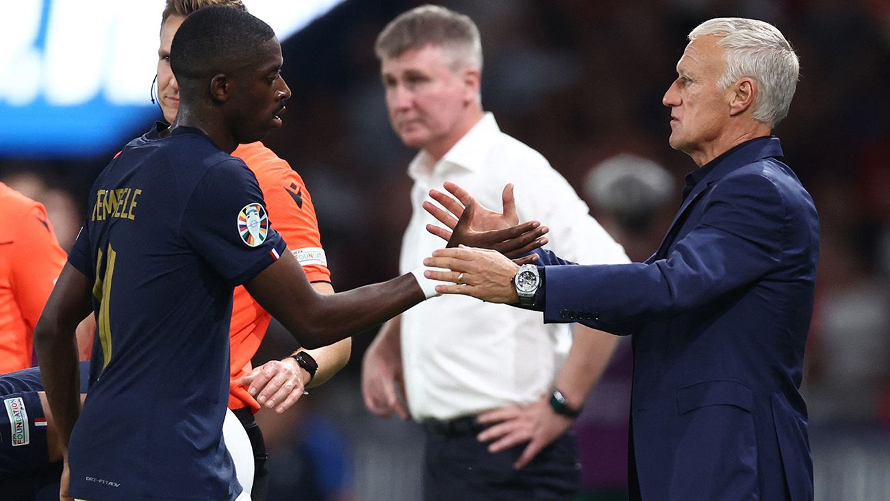 Ousmane Dembélé and Didier Deschamps greet each other during a match