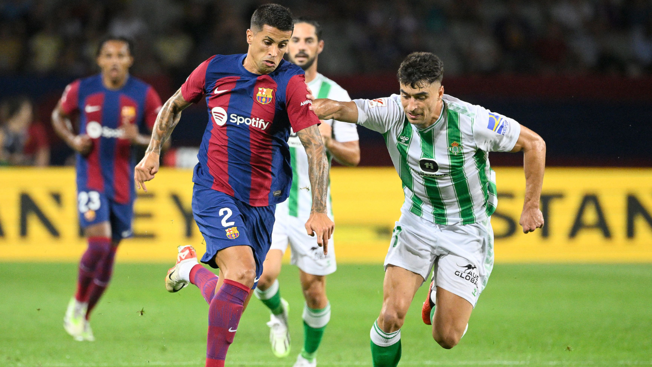 Joao Cancelo disputando un balón en el duelo entre el Barça y el Betis 