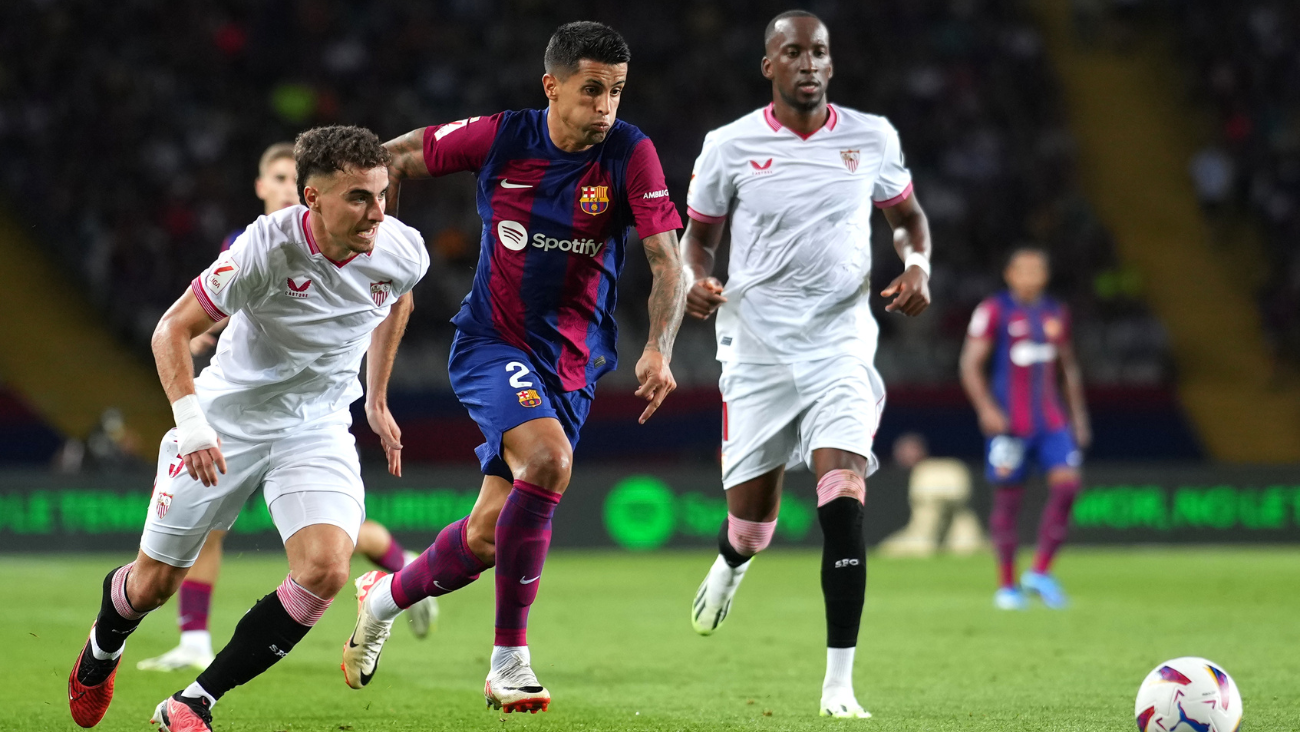Joao Cancelo en Barça Sevilla peleando un balón contra Adria Pedrosa y Dodi Lukebakio