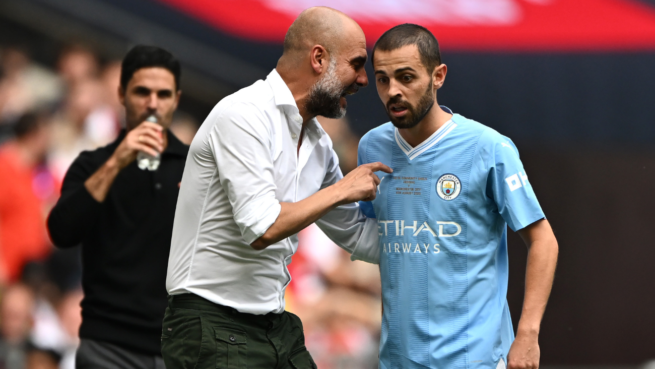 Bernardo Silva recibiendo una indicación técnica de Pep Guardiola