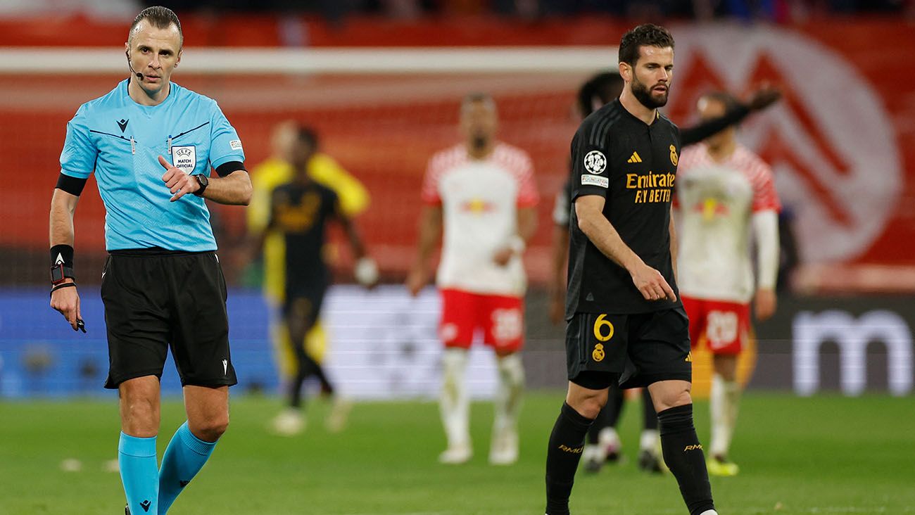 El árbitro Irfan Peljto y Nacho Fernández durante el Leipzig-Real Madrid