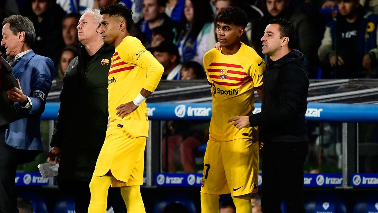 Raphinha y Lamine Yamal recibiendo instrucciones antes de saltar al campo