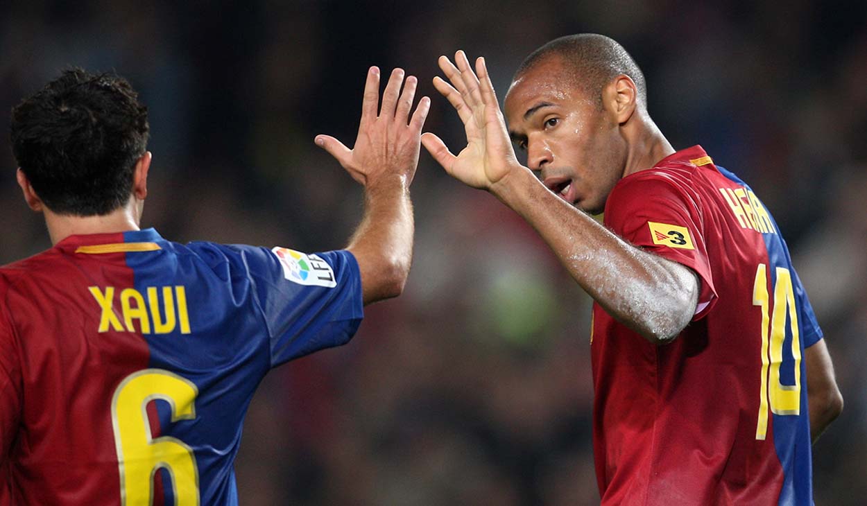 Xavi Hernández y Thierry Henry en un partido con el Barça