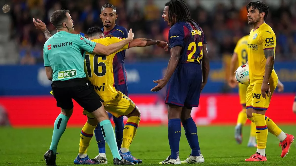 Raphinha y Jules Koundé del FC Barcelona reaccionan tras la caída de Diego Rico del Getafe